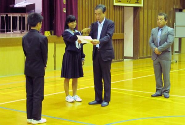 卒業生代表から生徒会長へ目録贈呈