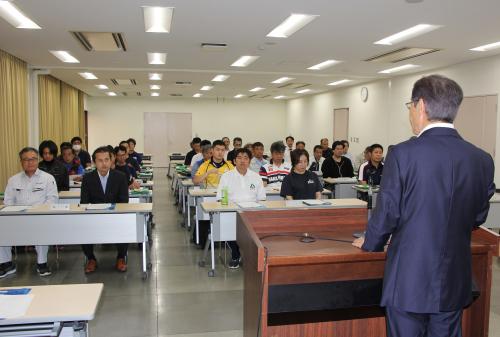 津久見市選手団と役員の紹介のあと、川野幸男団長から大分県障がい者スポーツ大会の陸上競技に出場する内田吉昭選手に団旗が手渡されました