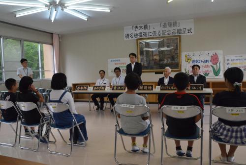 青江小学校では、青江川に架かる「赤木橋」と「道籠橋」に児童６名が、堅徳小学校では、徳浦川に架かる「上天神橋」に児童３名が、津久見小学校では、鍛冶屋川に架かる「橘橋」に児童３名がそれぞれ揮毫しました