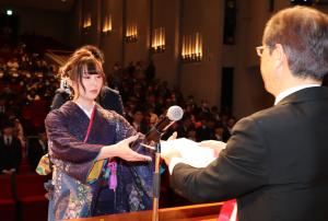 成人証書および記念が手渡されている様子です